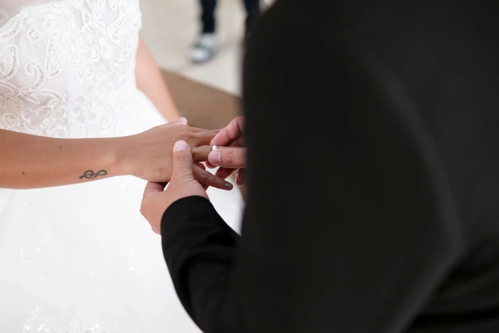 A groom places a ring on the bride's finger during a wedding ceremony, capturing a timeless moment.